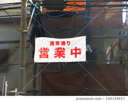 A scene with a sign that reads "Open for business as usual." 140144657