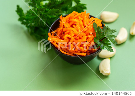 Organic spicy carrot salad with garlic cloves and herbs Organic spicy carrot salad with garlic cloves and herbs 140144865