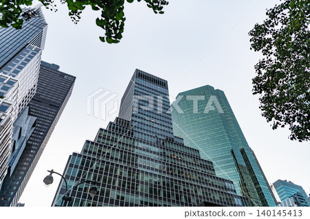 Modern glass building. Skyscraper in metropolis city. City downtown with skyscraper. Office building in business district. Skyscraper building architecture. Skyscraper with glass facade. Office block Modern glass building. Skyscraper in metropolis city. City downtown with skyscraper. Office building in business district. Skyscraper building architecture. Skyscraper with glass facade. Office block 140145413