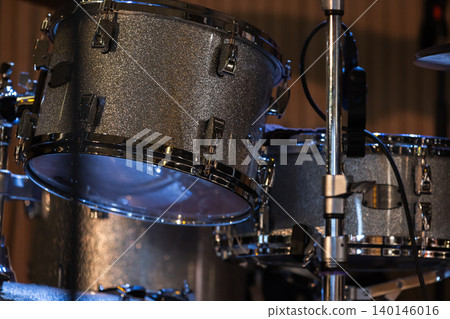 Close-up view of a glittering tom drum and drum kit Close-up view of a glittering tom drum and drum kit 140146016