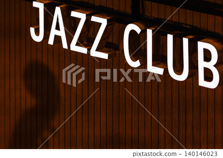 An illuminated JAZZ CLUB sign glows against wooden wall An illuminated JAZZ CLUB sign glows against wooden wall 140146023