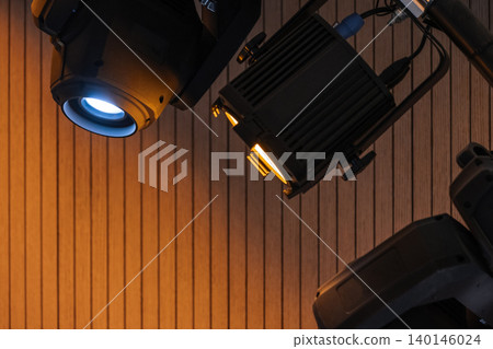 Two professional stage spotlights cast warm and cool beams 140146024
