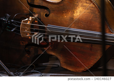 Close-up view of a vintage double bass resting onstage Close-up view of a vintage double bass resting onstage 140146027