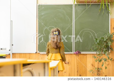 Young girl drawing a cloud and rainbow on a school chalkboard in a bright classroom, representing childhood creativity, early education, and learning in a supportive academic setting Young girl drawing a cloud and rainbow on a school chalkboard in a bright classroom, representing childhood creativity, early education, and learning in a supportive academic setting 140146316