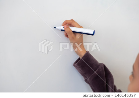 A person holds a blue marker against a blank white whiteboard surface to highlight a concept of creative brainstorming, educational teaching, or professional planning in an office A person holds a blue marker against a blank white whiteboard surface to highlight a concept of creative brainstorming, educational teaching, or professional planning in an office 140146357