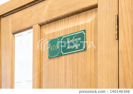 Green speech therapist office sign with number 416 mounted on a light wood door in a medical or educational institution, conveying professional guidance and health support service Green speech therapist office sign with number 416 mounted on a light wood door in a medical or educational institution, conveying professional guidance and health support service 140146366