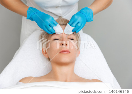 Professional cosmetologist does a deep mechanical cleaning of the client's face. Top view. Acne concept Professional cosmetologist does a deep mechanical cleaning of the client's face. Top view. Acne concept 140146546