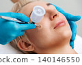 Professional cosmetologist does a gas-liquid peeling procedure of the client's face. Close up. Side view. The concept of cosmetology and aesthetic medicine 140146550