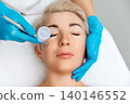 Cosmetologist in blue gloves does a gas-liquid peeling procedure of the client's face. Top view. The concept of professional cosmetology 140146552