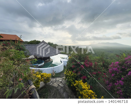 Hotel with pool on green volcano background Hotel with pool on green volcano background 140146718