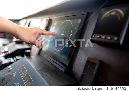 Captain hand pointing at marine radar monitor or GPS navigation on boat dashboard Captain hand pointing at marine radar monitor or GPS navigation on boat dashboard 140146860