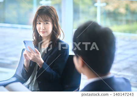 日本女商人及顧客透過智慧型手機提案 日本女商人及顧客透過智慧型手機提案 140147243