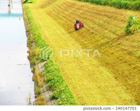 A scene of grass cutting on the Shinshiba River embankment in Kawaguchi City, Saitama Prefecture. A scene of grass cutting on the Shinshiba River embankment in Kawaguchi City, Saitama Prefecture. 140147701