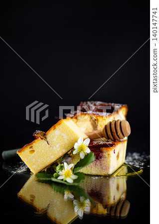 Baked cottage cheese squares with strawberry pieces on dark background Baked cottage cheese squares with strawberry pieces on dark background 140147741