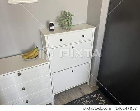 The jar of medicine is on the left side of the large cabinet 140147818