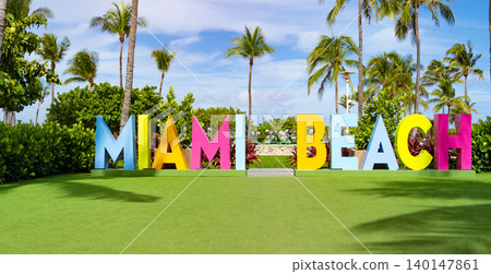 Miami beach sign. Miami beach sign text surrounded with tropical palm tree in summer vacation in exotic Florida Miami beach sign. Miami beach sign text surrounded with tropical palm tree in summer vacation in exotic Florida 140147861