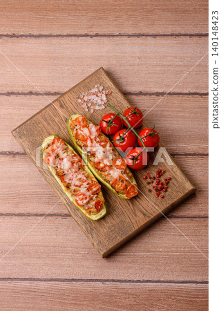 Baked zucchini half with minced meat, tomatoes, cheese, salt, and spices. Zucchini with minced meat Baked zucchini half with minced meat, tomatoes, cheese, salt, and spices. Zucchini with minced meat 140148423