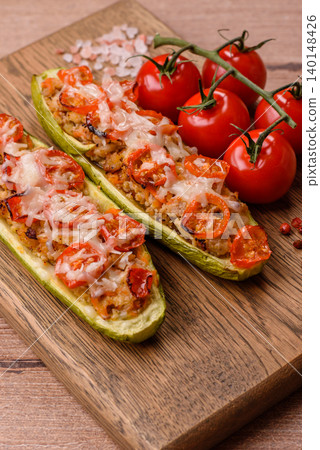 Baked zucchini half with minced meat, tomatoes, cheese, salt, and spices. Zucchini with minced meat Baked zucchini half with minced meat, tomatoes, cheese, salt, and spices. Zucchini with minced meat 140148426
