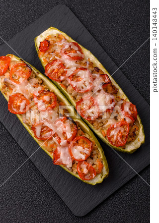 Baked zucchini half with minced meat, tomatoes, cheese, salt, and spices. Zucchini with minced meat 140148443
