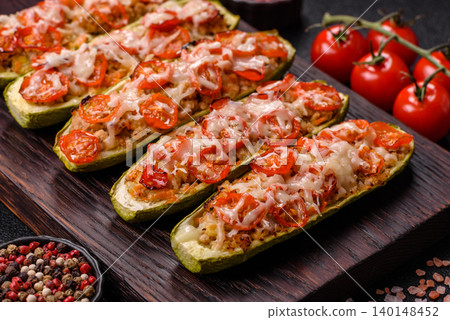 Baked zucchini half with minced meat, tomatoes, cheese, salt, and spices. Zucchini with minced meat 140148452