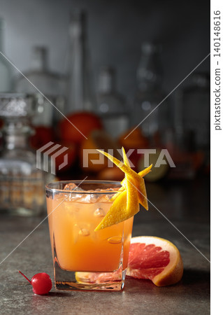 Cocktail with ice and grapefruit juice garnished with maraschino cherry and zest. Cocktail with ice and grapefruit juice garnished with maraschino cherry and zest. 140148616