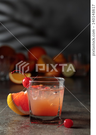 Cocktail with ice and grapefruit juice garnished with maraschino cherry. Cocktail with ice and grapefruit juice garnished with maraschino cherry. 140148617