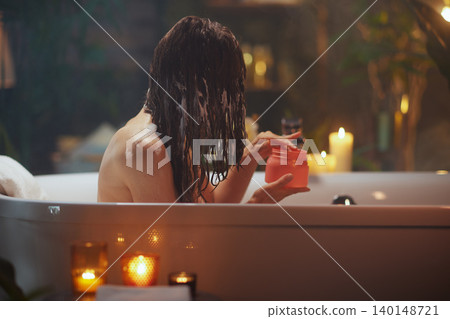 Woman Applying Hair Mask in a Cozy Candlelit Bath Woman Applying Hair Mask in a Cozy Candlelit Bath 140148721