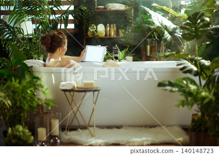 Woman Unwinding with Tablet in a Lush Spa Bath Woman Unwinding with Tablet in a Lush Spa Bath 140148723