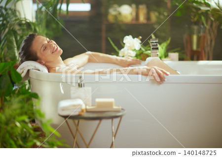 Blissful Bath: Woman in Greenery-Filled Retreat Blissful Bath: Woman in Greenery-Filled Retreat 140148725