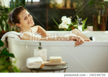 Smiling Woman Enjoying a Tranquil Bubble Bath Smiling Woman Enjoying a Tranquil Bubble Bath 140148730