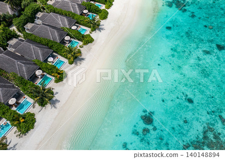 Amazing aerial Maldives villas private pools powdery white sand turquoise lagoon breathtaking luxury resort top view tropical paradise serene idyllic coastal escape drone dreamy vibrant exotic getaway 140148894