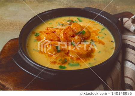 Creamy shrimp curry with spices, garnished with herbs, on a textured background, homemade , no people, Creamy shrimp curry with spices, garnished with herbs, on a textured background, homemade , no people, 140148956