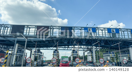 Toll plaza checkpoint with payment lanes cars and highway infrastructure under blue sky in Poland 140149128