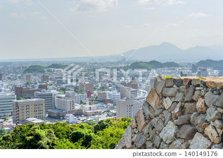 A breathtaking panoramic view of Yonago city and the surrounding mountains, seen from the castle tower base of Yonago Castle ruins, overlooking the imposing stone walls in the foreground (Yonago City, Tottori Prefecture). A breathtaking panoramic view of Yonago city and the surrounding mountains, seen from the castle tower base of Yonago Castle ruins, overlooking the imposing stone walls in the foreground (Yonago City, Tottori Prefecture). 140149176