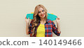 Stylish young blonde woman posing with skateboard on city street 140149466