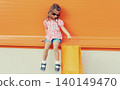 Little girl child with shopping bags posing on city street 140149470