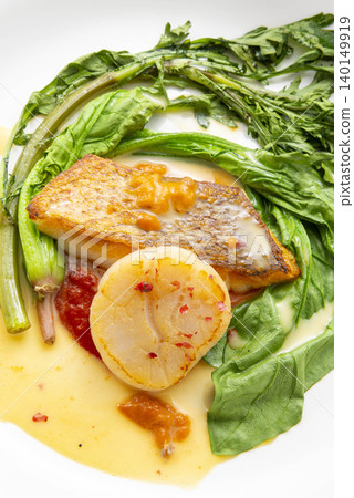 A refined Japanese dish featuring grilled fish, scallops, and vegetables. A refined Japanese dish featuring grilled fish, scallops, and vegetables. 140149919