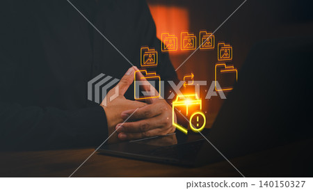 Person using a laptop experiencing a data sync error. A glowing file security icon is highlighted with a warning sign, illustrating backup failure, a computer problem, and a data alert or technology Person using a laptop experiencing a data sync error. A glowing file security icon is highlighted with a warning sign, illustrating backup failure, a computer problem, and a data alert or technology 140150327