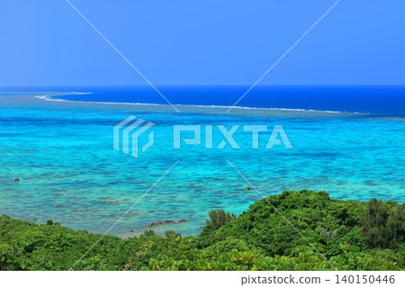 [Okinawa Prefecture] Coral reefs of Iharama Bay as seen from Tamatorizaki Observatory on a clear day (Ishigaki Island) 140150446