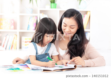 Asian Mother and Daughter Laughing Together While Studying Asian Mother and Daughter Laughing Together While Studying 140151012
