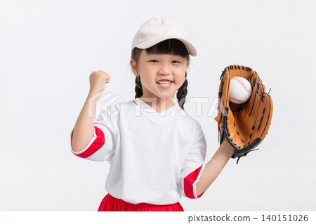 A cheerful young girl wearing a baseball uniform and holding a glove with a ball. A cheerful young girl wearing a baseball uniform and holding a glove with a ball. 140151026