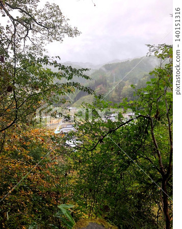 透過樹木可以看到霧氣繚繞的山村——秋日景色。 140151316
