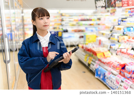 店內,一名女子正在使用平板電腦。 店內,一名女子正在使用平板電腦。 140151368