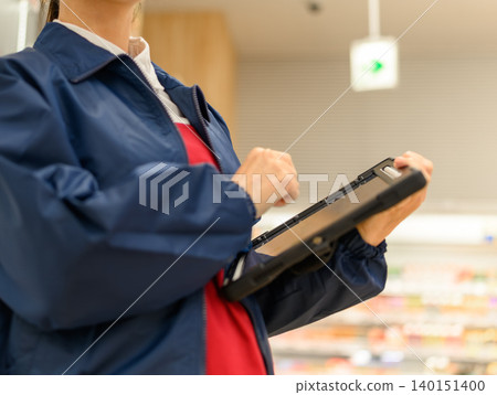 女店員正在操作平板電腦 140151400