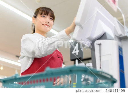 Female store clerk working at the register 140151409