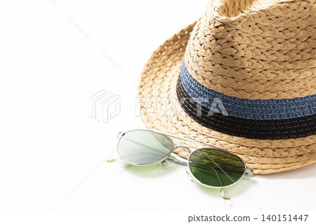 A straw hat and sunglasses against a white background. A straw hat and sunglasses against a white background. 140151447
