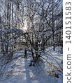 Sunlight through snow-covered trees in winter forest 140151583