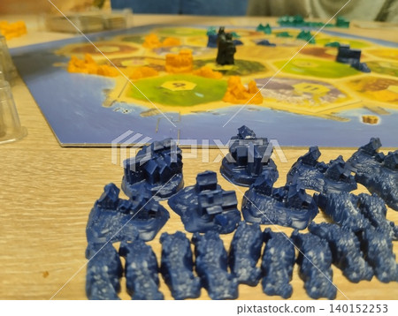 Mozyr, Belarus, April 10 2025: board game Colonizers Catan Katan. The player's blue chips lie in front of the playing field Mozyr, Belarus, April 10 2025: board game Colonizers Catan Katan. The player's blue chips lie in front of the playing field 140152253