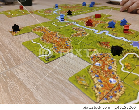 Mozyr, Belarus, April 10 2025: Carcassonne A colored chip lies in the field of the playing field Mozyr, Belarus, April 10 2025: Carcassonne A colored chip lies in the field of the playing field 140152260