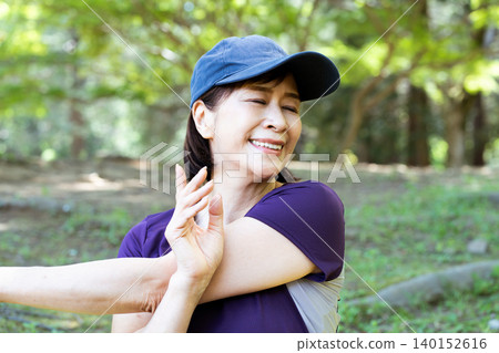Middle-aged women stretching outdoors Middle-aged women stretching outdoors 140152616